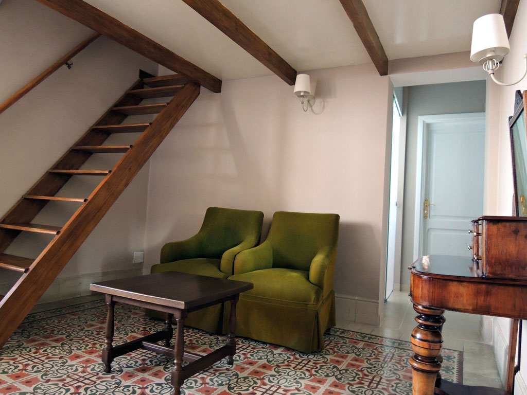 Salon avec deux fauteuils, table basse et escalier en bois à Tenerife.
