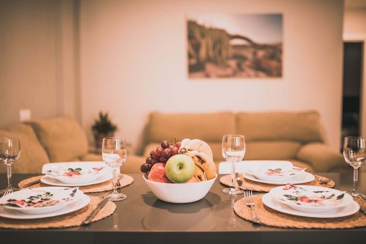 Bol de fruits et vaisselle sur table dressée dans un salon à Tenerife.