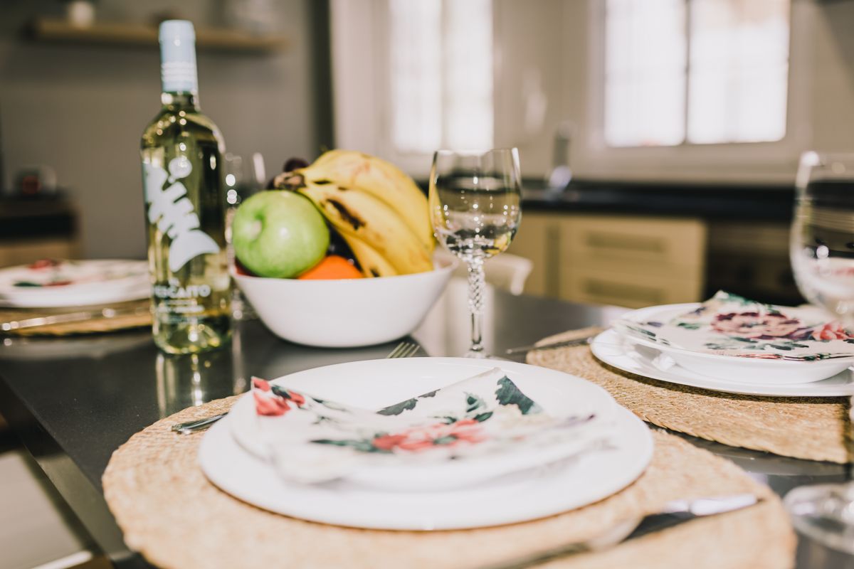 Bouteille de vin blanc, bol de fruits et assiette sur une table à Tenerife.
