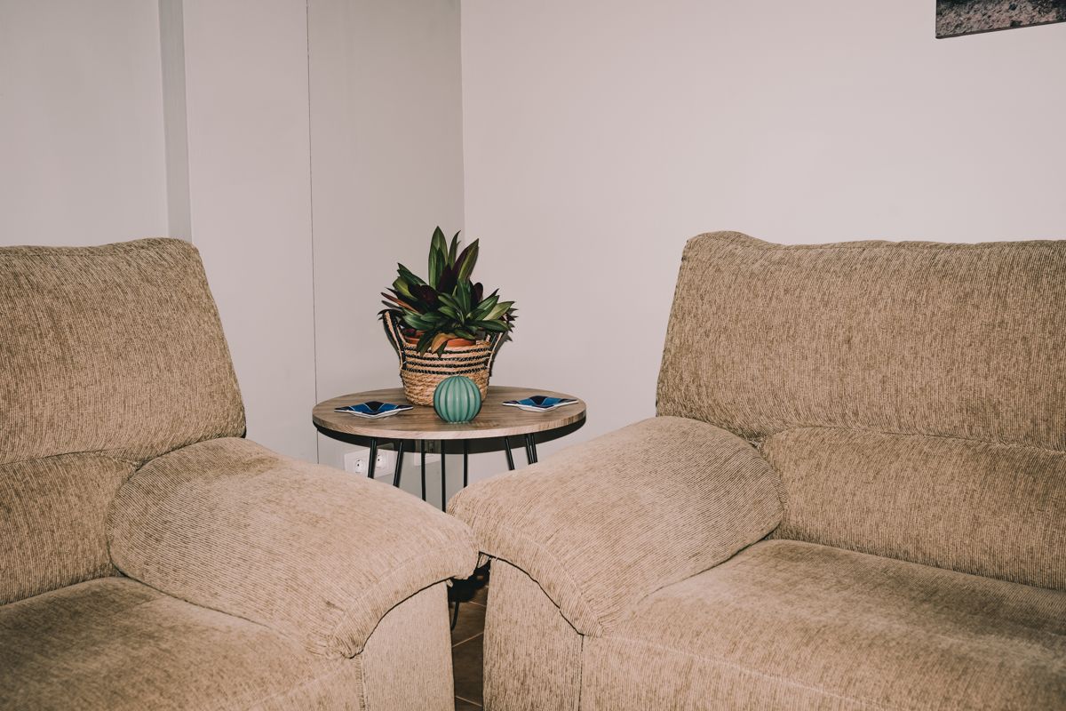 Deux fauteuils beiges entourant une table ronde avec plante à Santa Cruz de Tenerife.