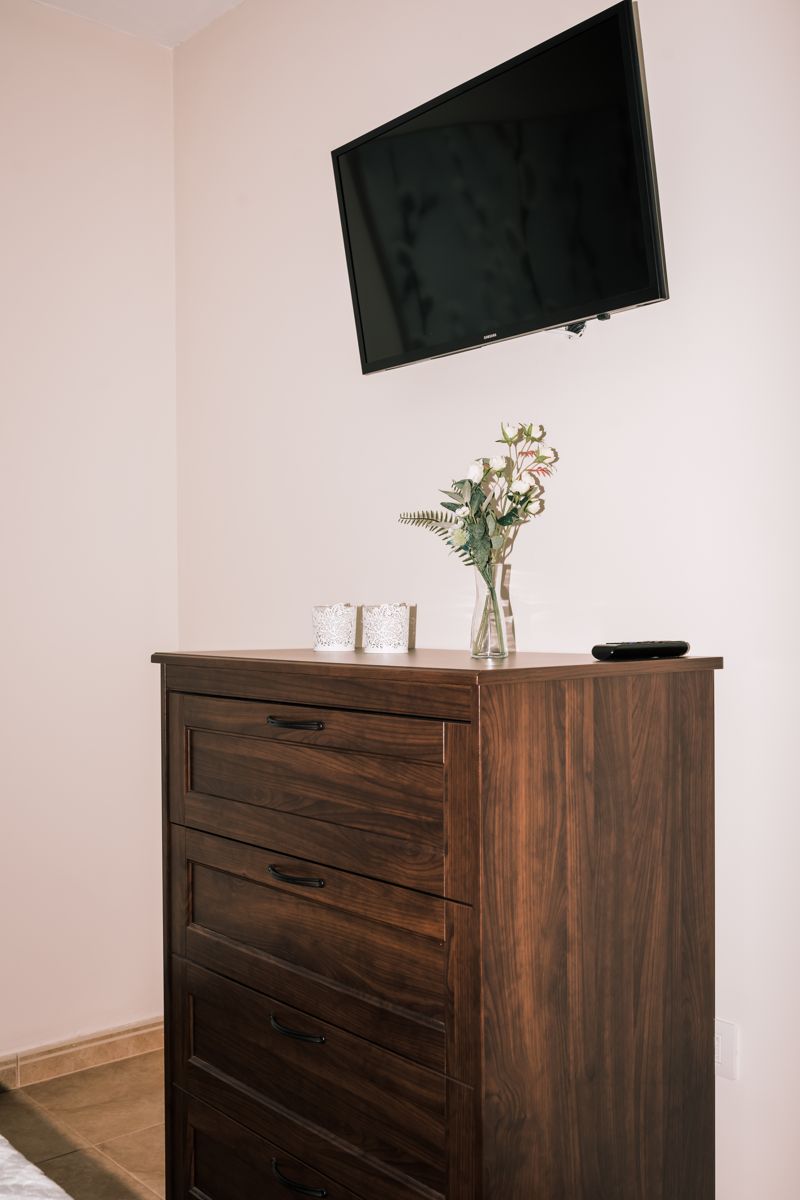 Télévision murale et commode en bois avec vase à fleurs à Tenerife.