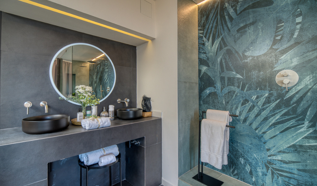 Salle de bain moderne avec miroir rond et décoration murale à Tenerife.
