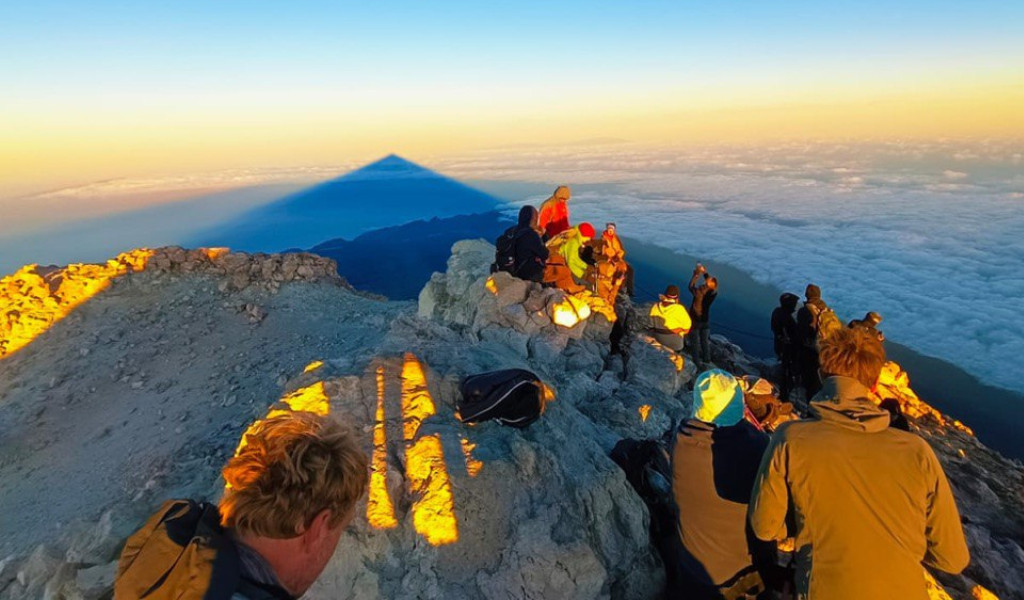 Des personnes au sommet du Teide, Tenerife, admirant un lever de soleil et des nuages.