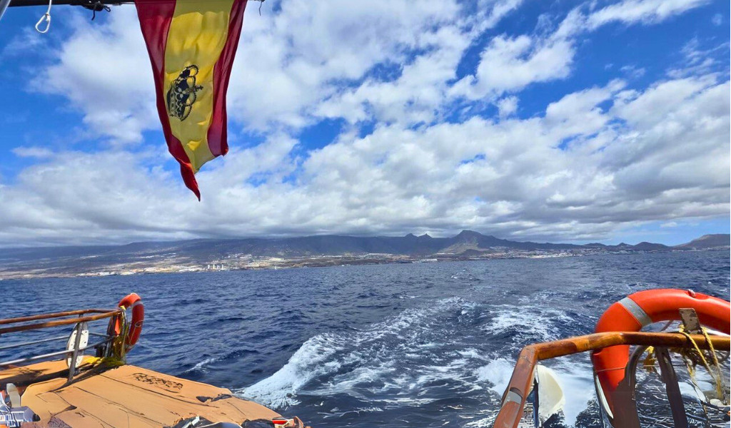 Drapeau espagnol vu depuis un bateau avec Costa Adeje en arrière-plan.