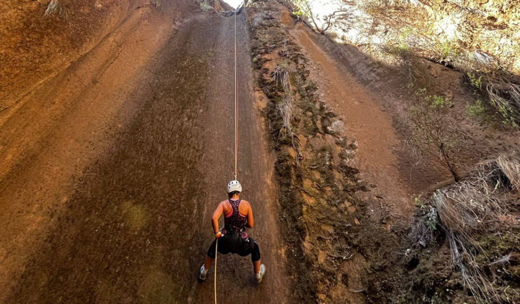 Escaladeur descendant une paroi rocheuse avec une corde à Tenerife.