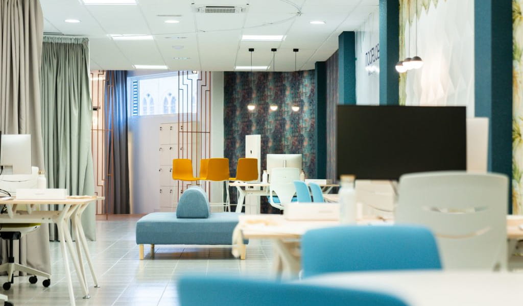 Espace de coworking moderne à Tenerife avec bureaux et chaises colorées.