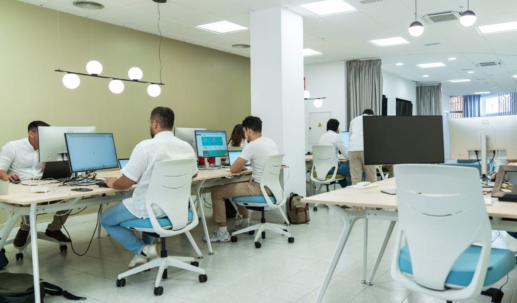 Personnes travaillant sur des ordinateurs dans un bureau à Tenerife.