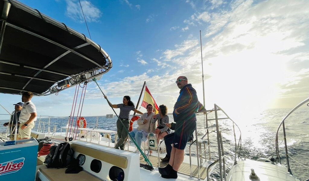 Personnes sur un bateau naviguant sur l'océan près de Tenerife au coucher du soleil.