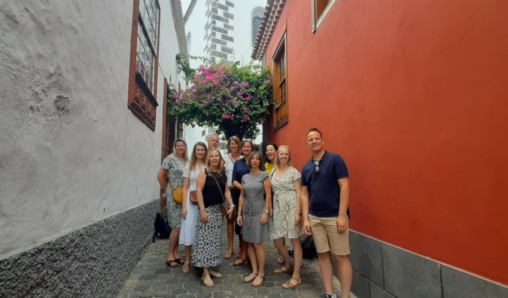 Un groupe de personnes souriantes dans une ruelle colorée à Tenerife.