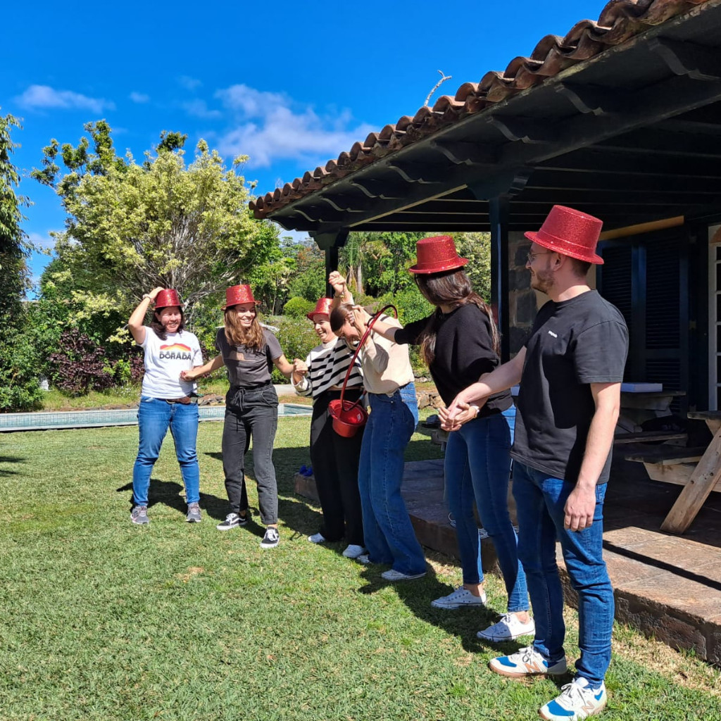 Un groupe de personnes portant des chapeaux rouges se tenant la main à l'extérieur à Tenerife.