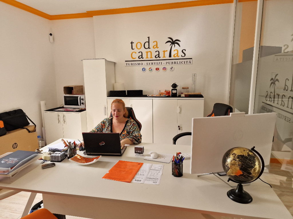 Femme travaillant dans le bureau de Toda Canarias, avec un ordinateur et des papiers sur le bureau.