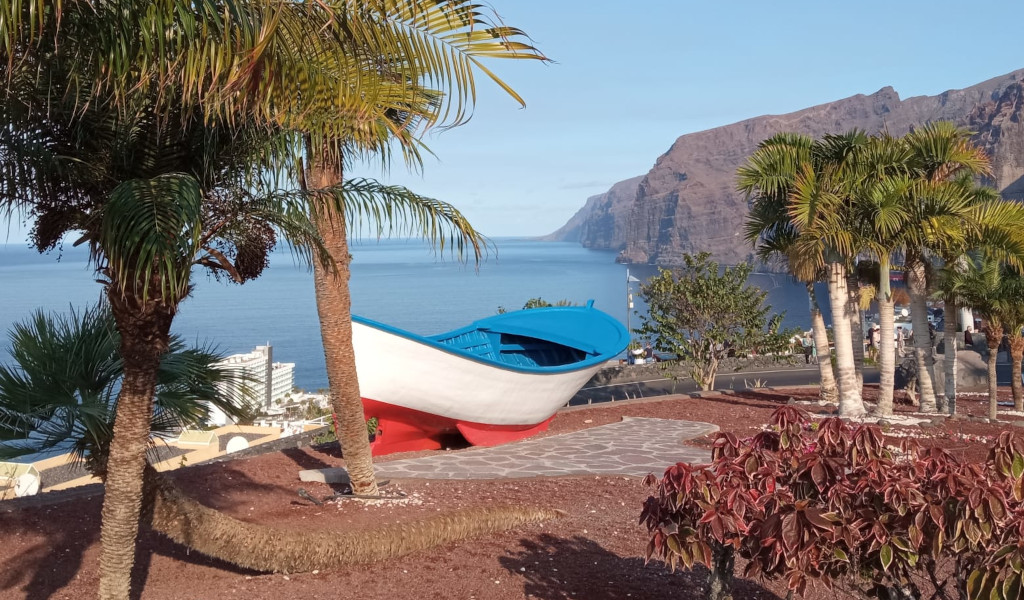 Bateau bleu et blanc dans un parc avec vue sur Los Gigantes, Tenerife.