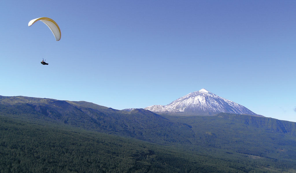 Parapente au-dessus du mont Teide à Tenerife sous un ciel dégagé.