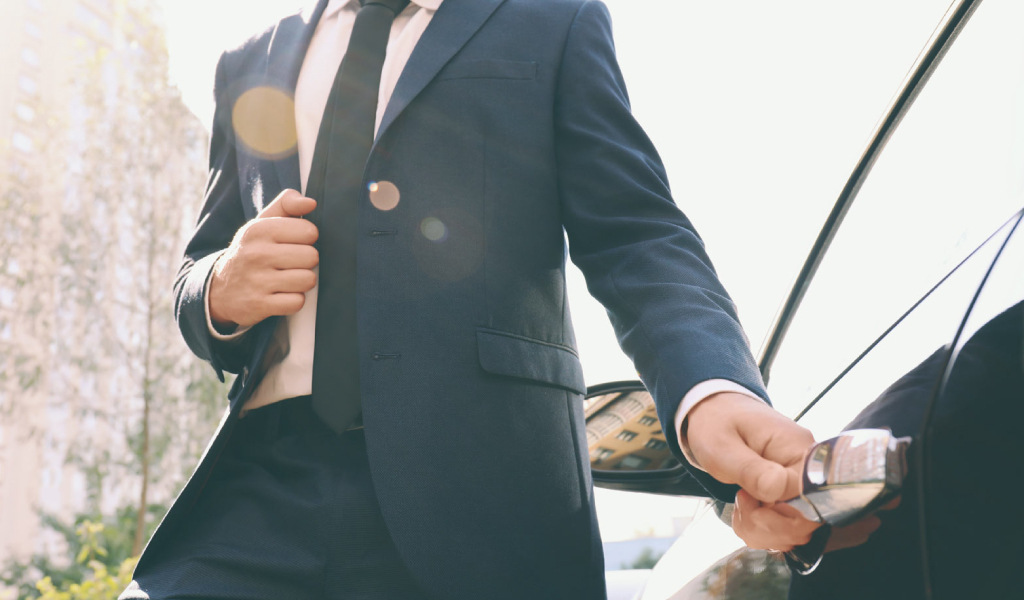 Un homme en costume ouvrant la porte d’une voiture à Tenerife.