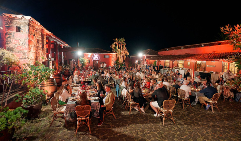 Des gens dînent en plein air dans une finca à Tenerife pendant la nuit.