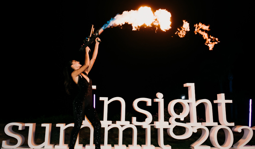 Personne lance-flammes à côté des lettres du sommet de l’insight 2021 lors d’un événement nocturne à Tenerife.