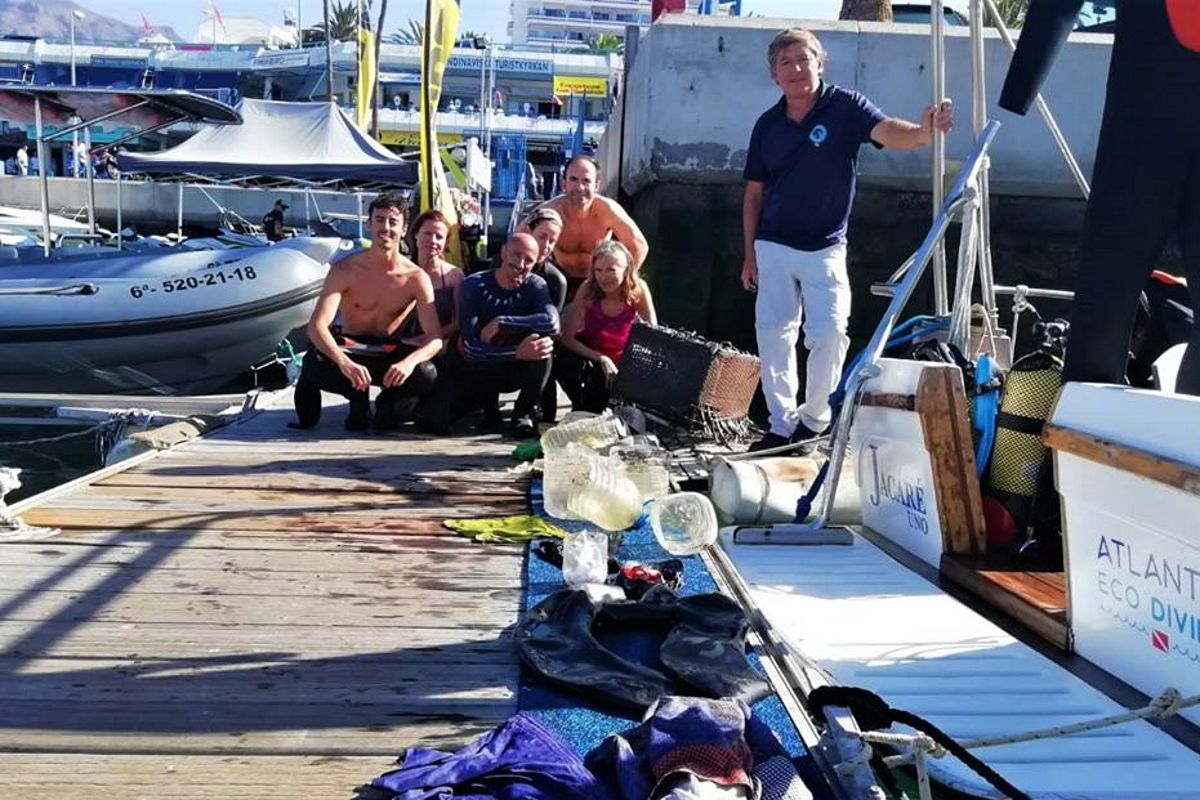 Des gens sur le quai avec du matériel de plongée et des ordures ramassées à Tenerife.