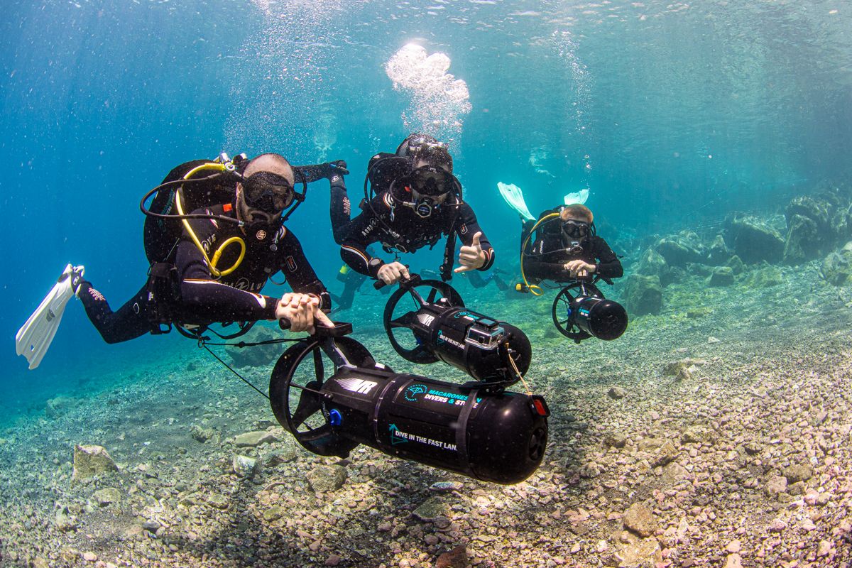 Des plongeurs équipés de propulseurs sous-marins explorant des eaux cristallines à Tenerife.