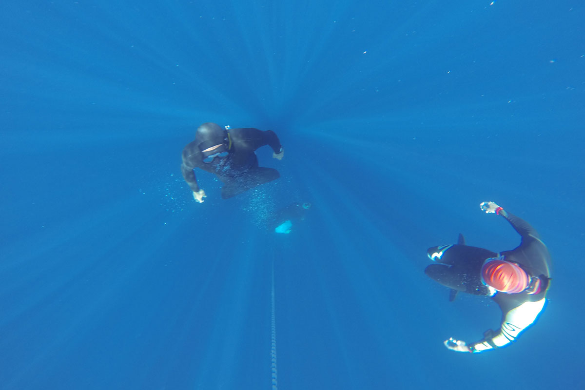 Des plongeurs dans les eaux de Tenerife, dont un avec une combinaison rouge.