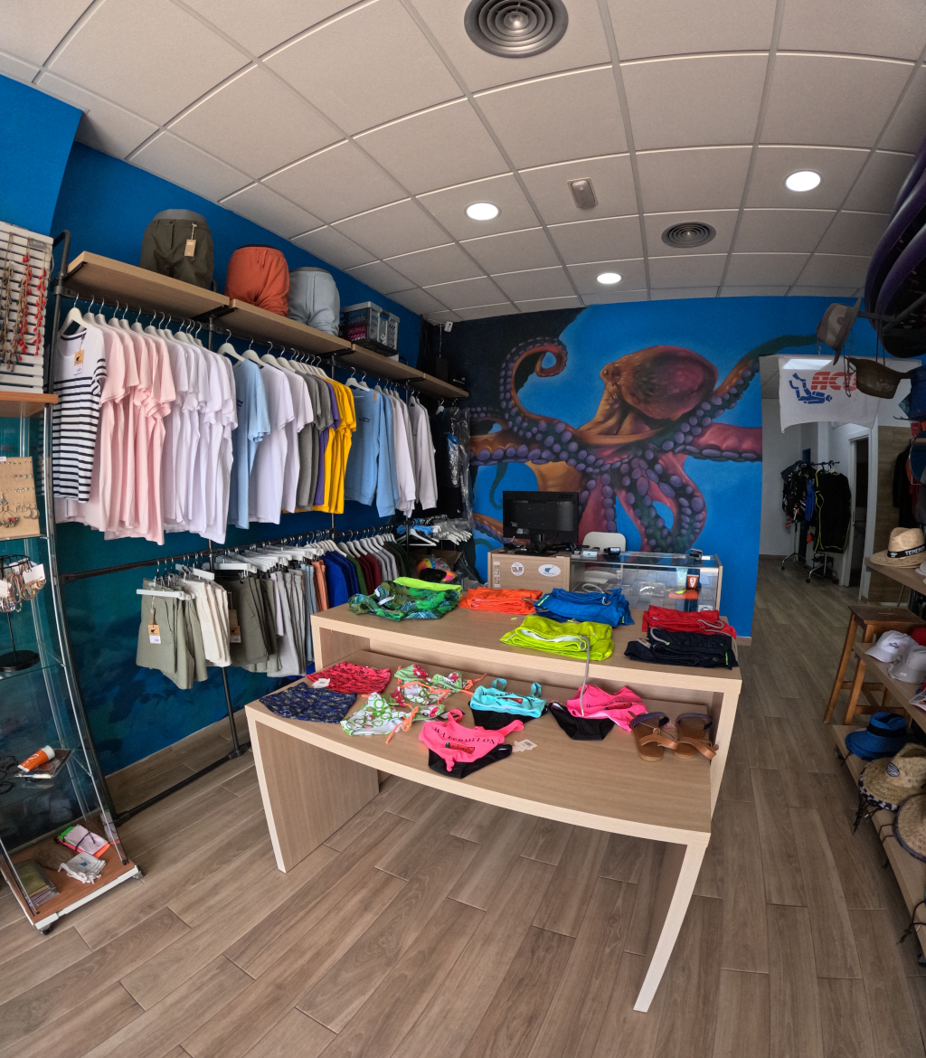 Magasin de vêtements avec t-shirts et pantalons exposés à Tenerife.