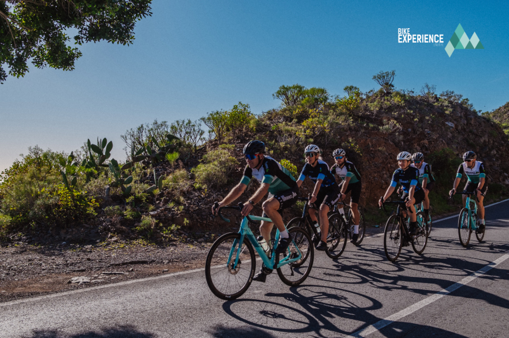 Cyclistes sur un itinéraire montagneux à Tenerife, avec le logo Bike Experience.