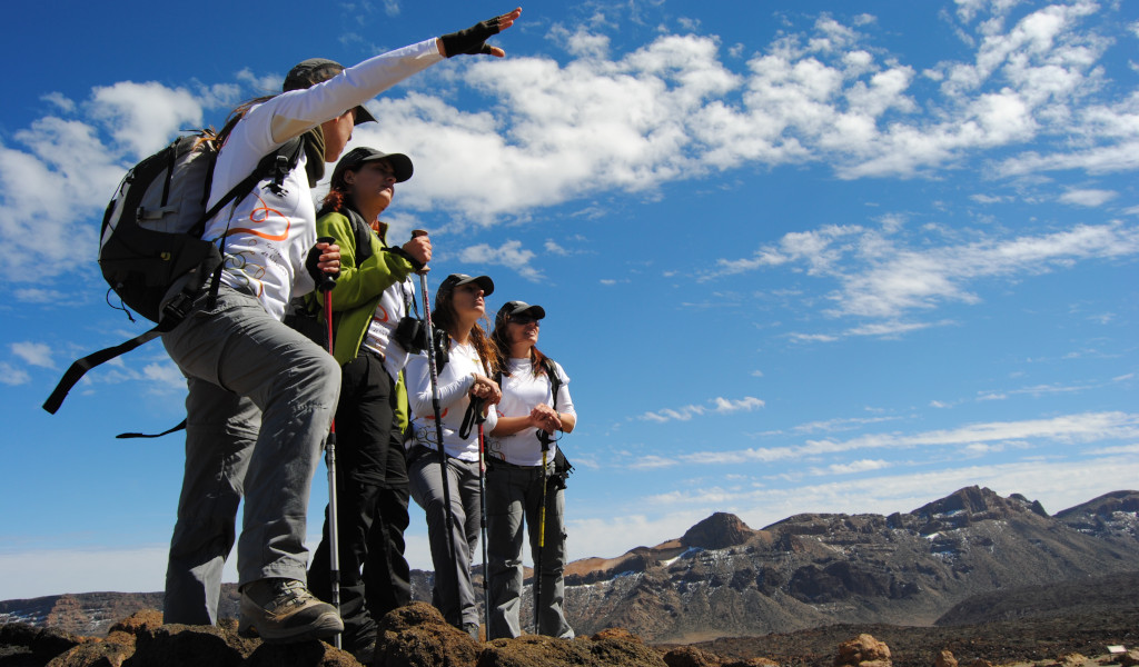 Groupe de randonneurs dans le parc national de la Teide, à Tenerife, avec des montagnes en arrière-plan.