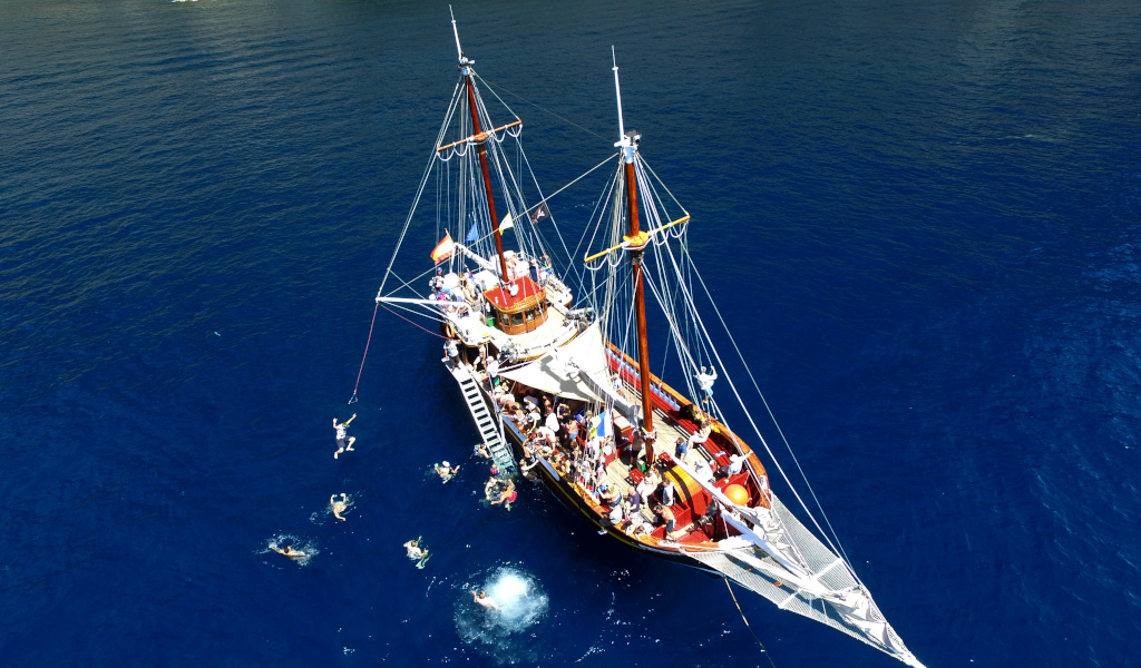 Bateau touristique avec des gens qui nagent près de Tenerife.