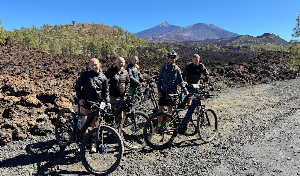 Des cyclistes sur un sentier volcanique avec le mont Teide en arrière-plan à Tenerife.
