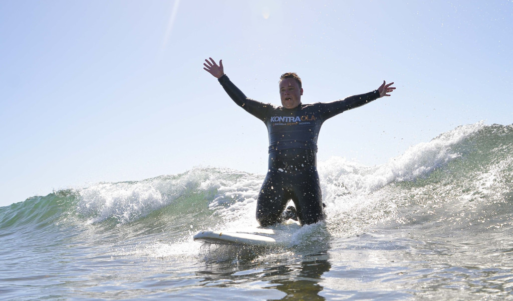 Surfeur sur la vague avec les bras tendus, t-shirt Kontraola. Surf à Tenerife.