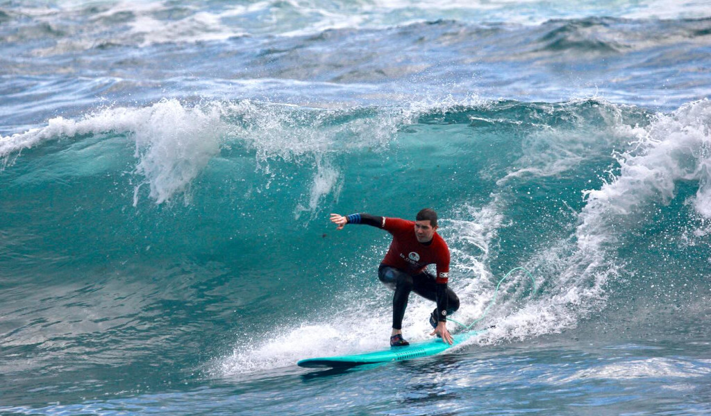 Surfeur chevauchant une vague sur la plage à Tenerife.