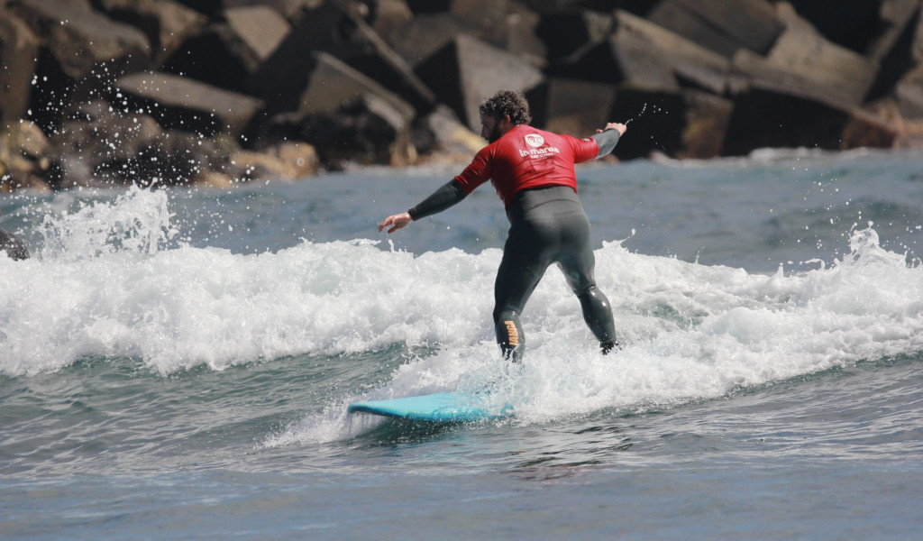 Personne surfant sur une petite vague dans la mer de Tenerife.