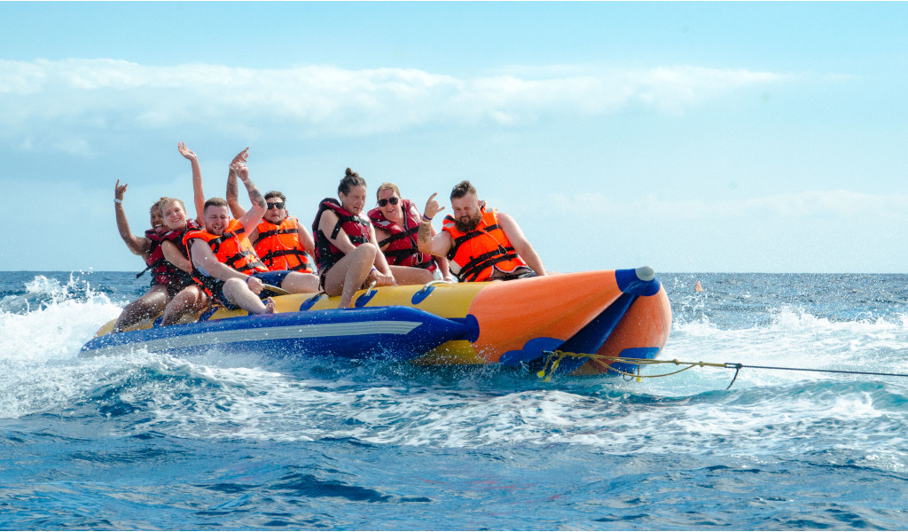 Des gens sur un bateau pneumatique à bananes au-dessus de la mer lors d’une activité aquatique à Tenerife.