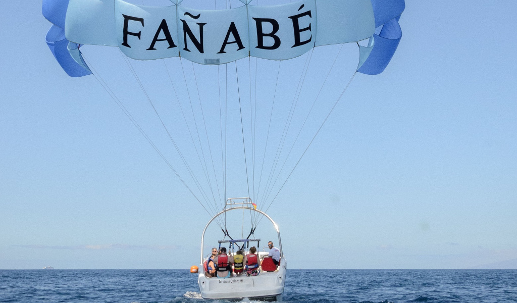 Des gens faisant du parachute ascensionnel à Fañabé, Tenerife, au-dessus de la mer.