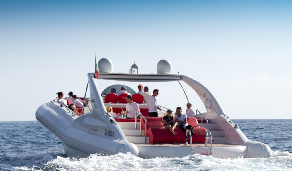Des gens profitant d’un tour sur un bateau aux sièges rouges en mer près de Tenerife.