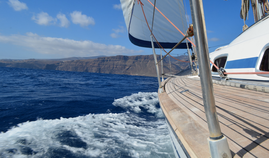 Voilier naviguant près de la côte de Tenerife avec des montagnes en arrière-plan.