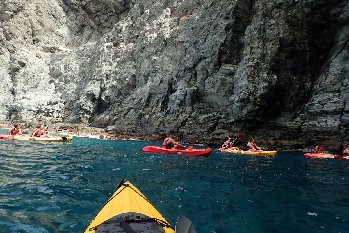 Des gens font du kayak le long des falaises sur la côte de Tenerife.