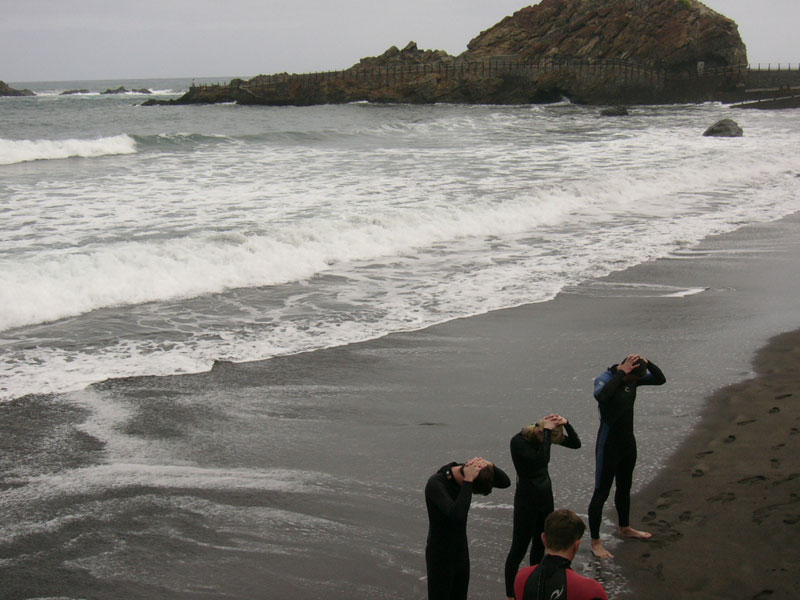 Des gens en combinaisons sur la plage El Roque de las Bodegas, à Tenerife.