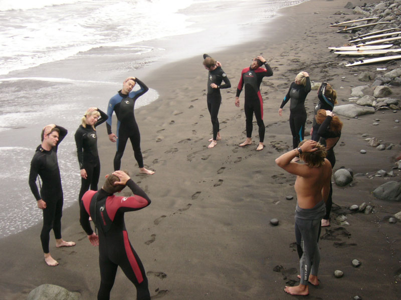 Groupe de surfeurs s’étendant sur la plage de Tenerife.