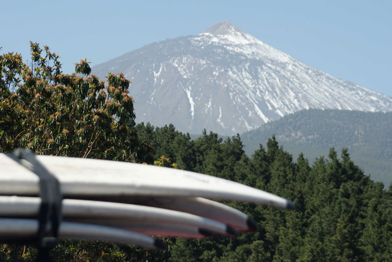 Des planches de surf empilées avec le mont Teide en arrière-plan à Tenerife.
