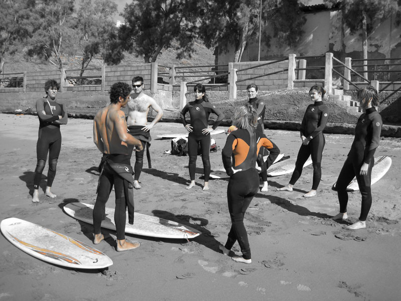Groupe de personnes en combinaison recevant des instructions sur une plage à Tenerife.