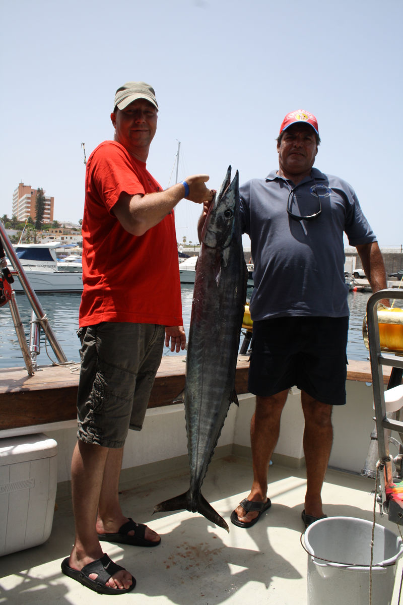 Deux personnes sur un bateau transportant un gros poisson à Los Cristianos, Tenerife.