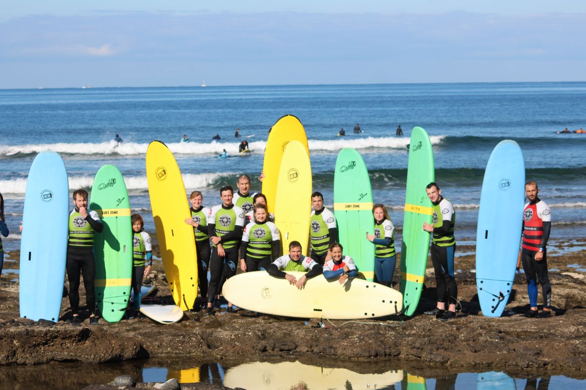 Groupe de surfeurs avec des planches colorées sur la plage de Tenerife.