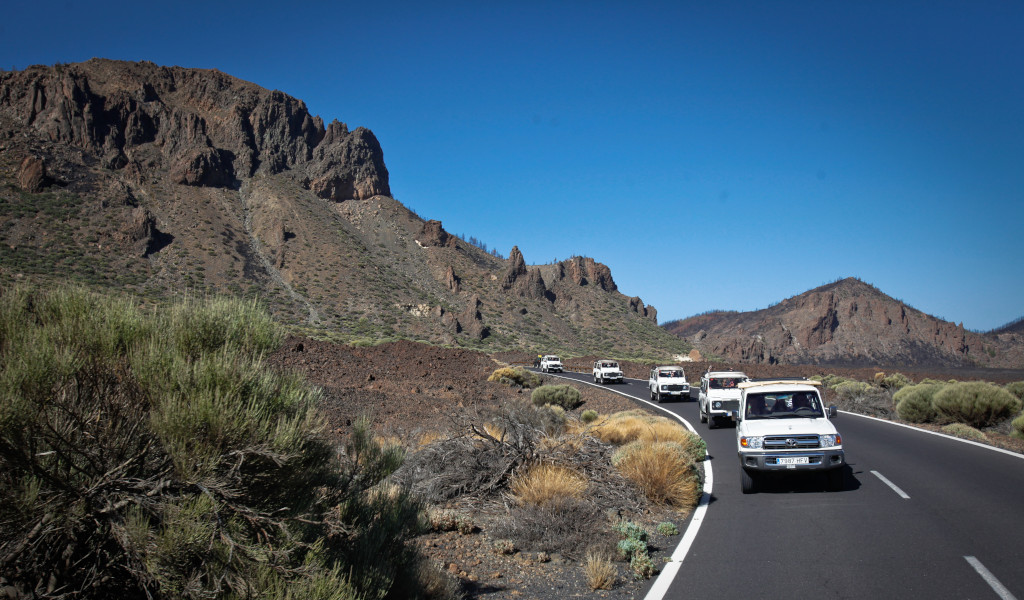 Caravane de voitures sur la route du mont Teide, à Tenerife, entourée de montagnes.