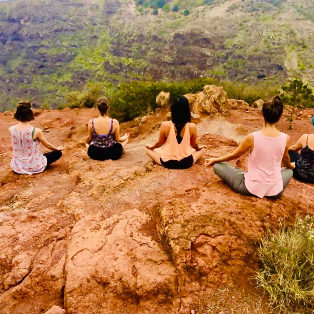 Des gens méditant en plein air sur une falaise à Tenerife.