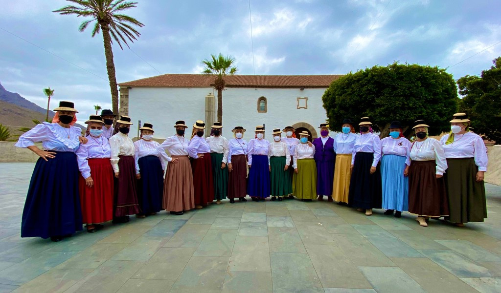 Groupe de personnes en costumes traditionnels à La Gomera, Tenerife, devant un bâtiment.