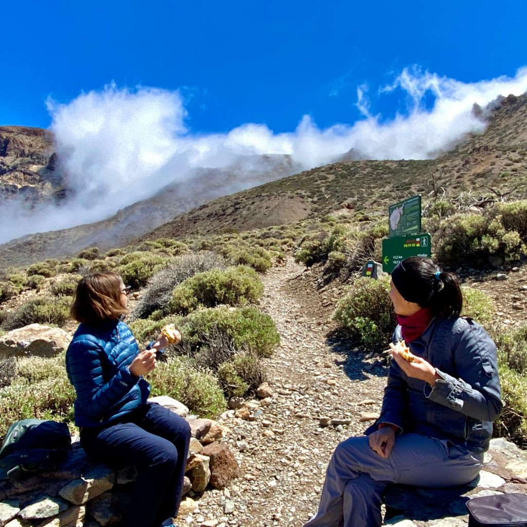 Des gens assis en train de manger sur un sentier dans le parc national du Teide, à Tenerife.