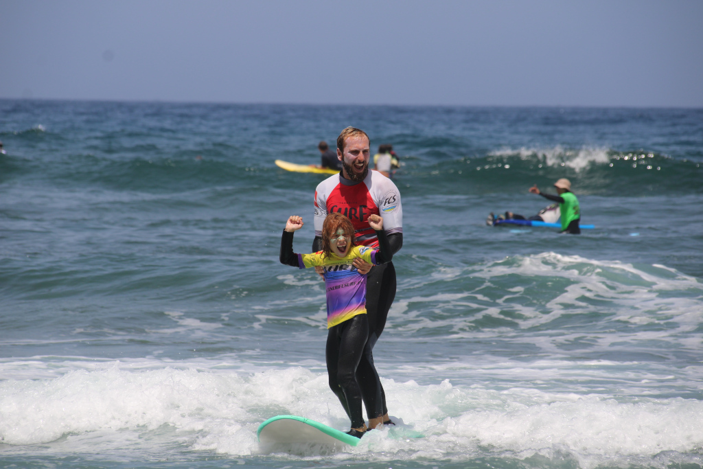 Surfeur adulte et enfant en cours de surf sur une plage à Tenerife.