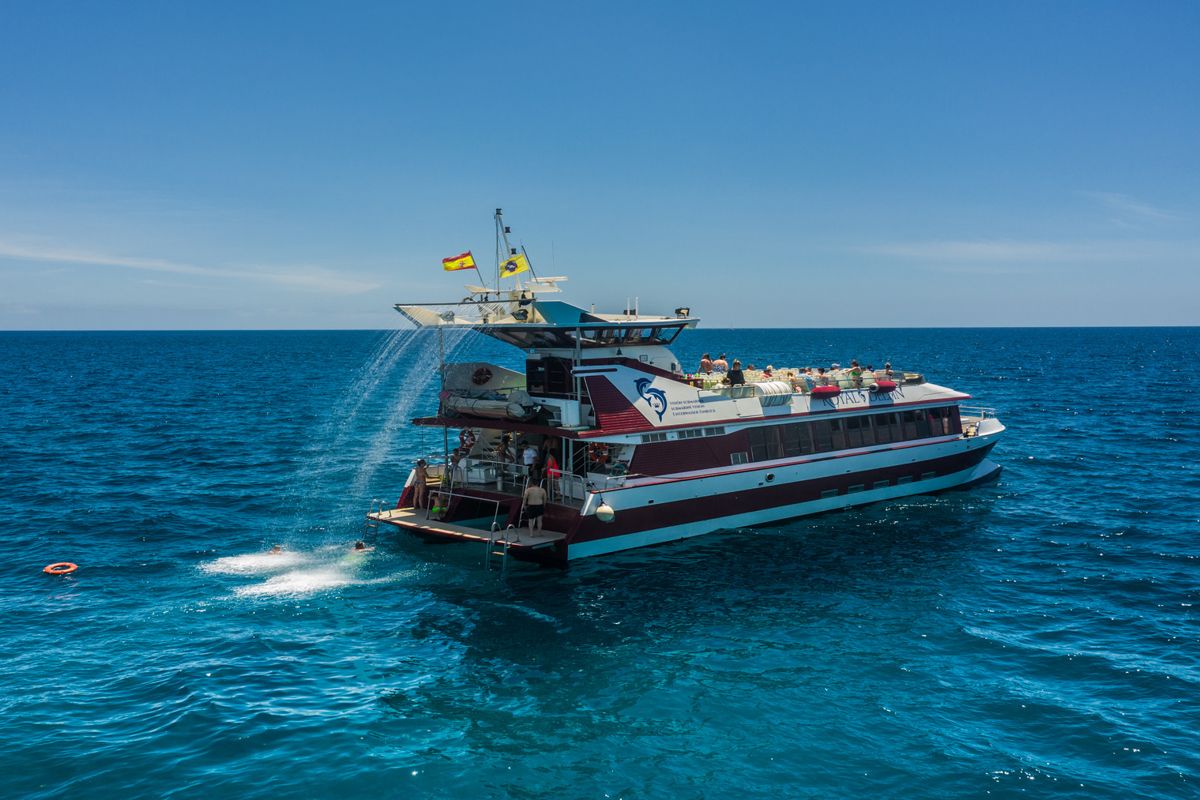 Bateau touristique sur l’océan près de Tenerife, avec passagers et drapeau espagnol.