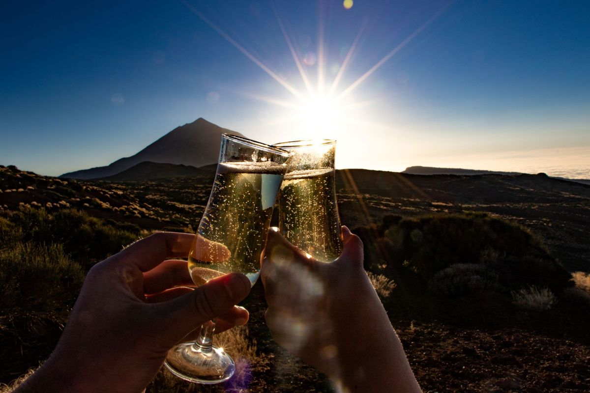 Un toast avec des verres de champagne au coucher du crépuscule près du mont Teide, à Tenerife.