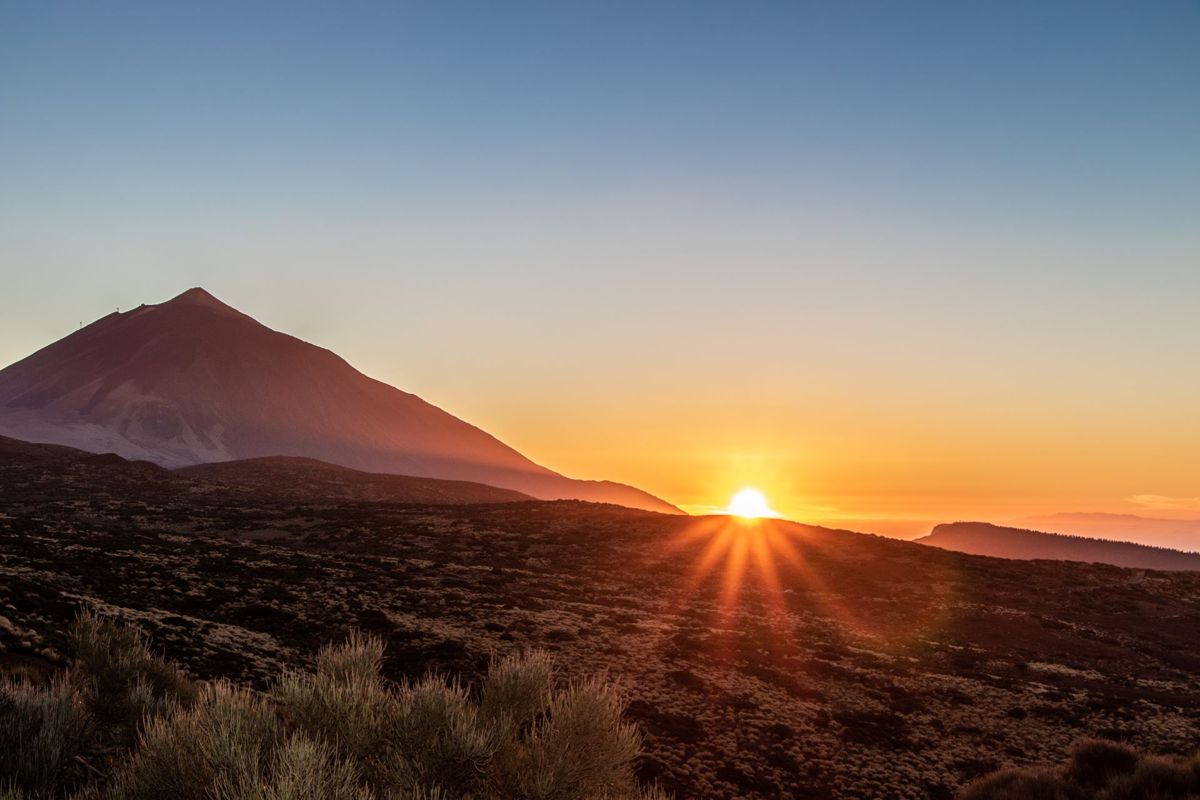 Le lever du soleil sur le mont Teide, à Tenerife, avec le soleil qui perçant derrière l’horizon.